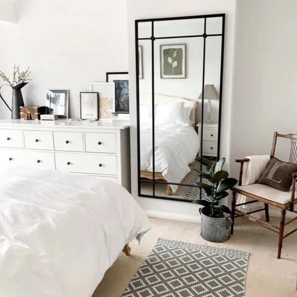 a long vertical mirror in a white bedroom for mans
